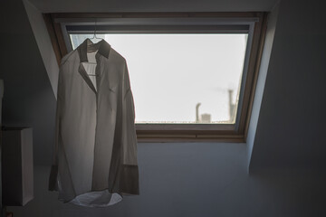 Fototapeta na wymiar White shirt hanging to dry in front of the window