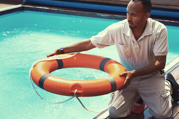 African hotel worker throws a lifeline to man drowning pool. Salvation of a sinking person