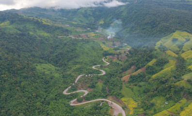 Aerial view of cars driving on curved, zigzag curve road or street on mountain hill with green...