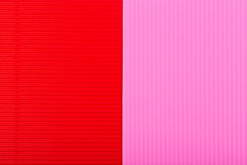 Red and pink background with stripes. Paper textured backdrop. Abstract colorful wallpaper. Corrugated red and pink paper