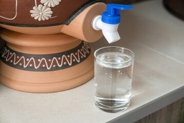 A glass of water from traditional water dispenser called Labu Sayong (water calabash) in Malay language.