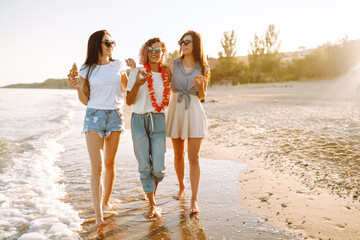 Three young woman eating pizza and have fun on the beach. Fast food concept.  Summer holidays,...