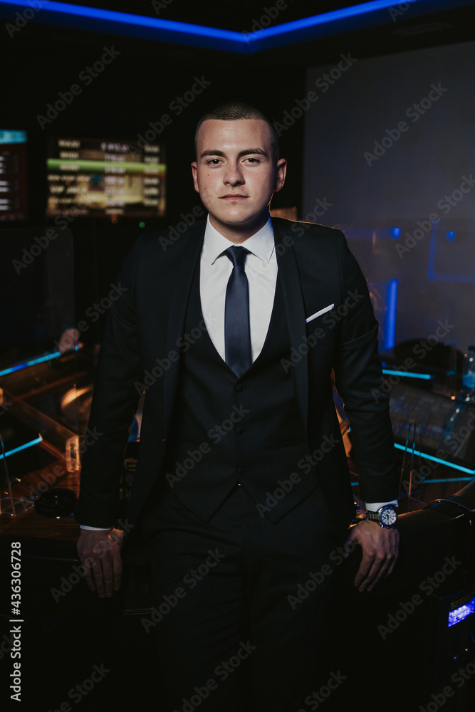 Wall mural vertical shot of a handsome bosnian caucasian man wearing a suit, posing indoors