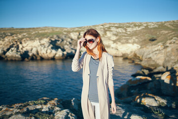 red-haired woman travels in the mountains near the river in nature front view model