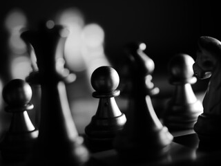 Selective focus shot of pawn chess piece on board against a bokeh background