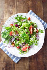Salad with Olives, Tomatoes, Endive   and Red Onion. Rustic wooden background. Top view. 
