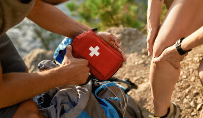 Young caucasian man holding first aid kit for healing - obrazy, fototapety, plakaty