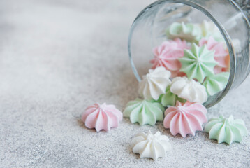 Obraz na płótnie Canvas Small white, pink and green meringues in the glass