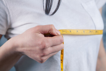 young girl measures breast girth