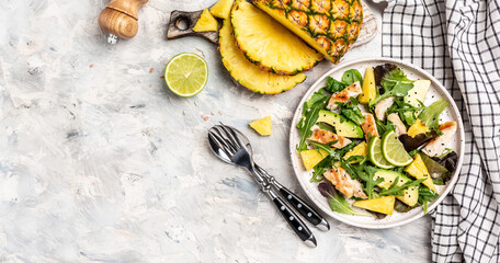 pineapple salad, grilled chicken breast, avocado, green rocket salad, lime and olive oil, sesame and seeds. banner, menu recipe place for text, top view