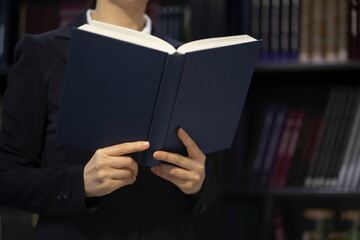  Lawyer Reading Book While Standing Against Bookshelf In Office 