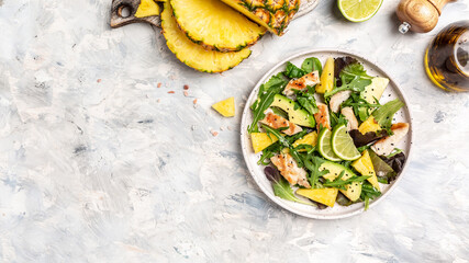 Pineapple salad with grilled chicken breast, avocado, green rocket salad, lime and olive oil, Healthy juicy food, banner, menu recipe place for text, top view