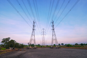 Fototapeta na wymiar high angle view of high voltage transmission towers with power line over twilight sky background the electricity infrastructure from power plant to industrial and household with morning dawn light