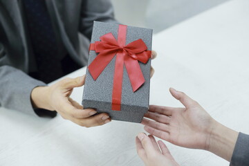 Close up of man giving gift box to woman