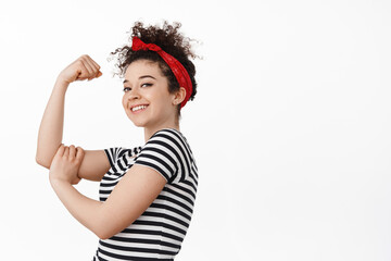 We can do it. Women power and feminism concept. Strong and confident brunette girl showing her arm...