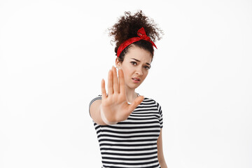 Stop it. Young brunette woman stretch hand and tell no, forbid something, blocking you, keep away...