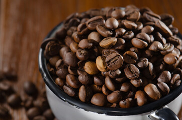 Fototapeta premium Roasted coffee beans lie in a white mug. View from above