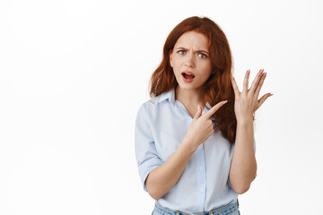 Angry girlfriend pointing at finger without ring, wants to get married, having fight with boyfriend about marriage and proposal, standing against white background