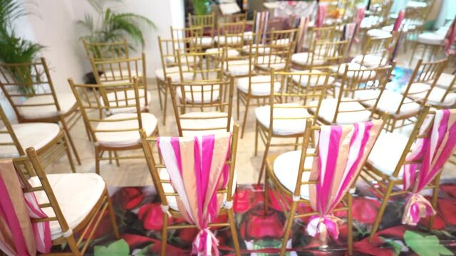Empty chairs at a party room ready to occupy. White empty chairs at a decorated  reception hall.