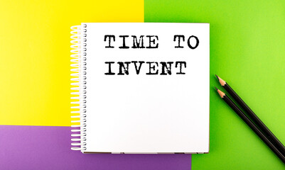 Minimal work space : sketchbook on the colorful background with TIME TO INVENT text