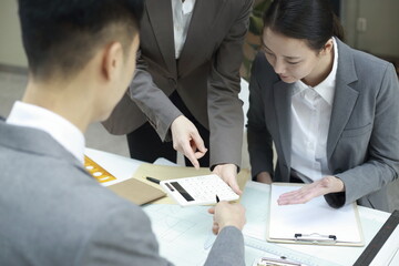 Business people using calculator in meeting