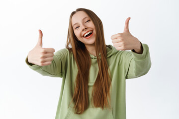 Super good. Smiling beautiful girl shows thumbs up and nod in approval, praise cool nice item,...