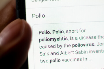 polio News on the phone.Mobile phone in hands. selective focus and chromatic aberration effects.
