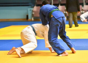 Two Boys judoka in kimono compete on the tatami 