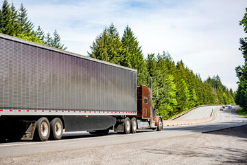 Brown bonnet classic big rig semi truck with refrigerator semi trailer transporting cargo driving...