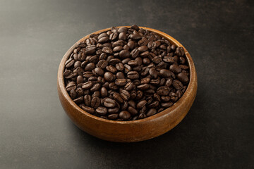 Fototapeta premium Coffee beans in wooden bowl on grunge background.