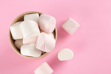 Marshmallow in bucket on pastel pink background.