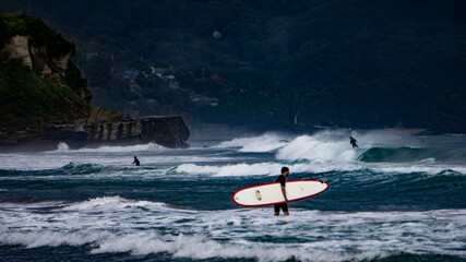 Surfers on a beach of Izu peninsula, Japan - obrazy, fototapety, plakaty