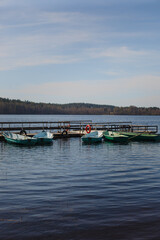 Empty old fishing boats with oars at the wooden pier. Lake with boats