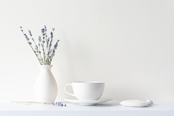 Still life with minimal composition, lavender dried bouquet, ceramic white cup and hot beverage tea or coffee, morning mood in beige tone - Powered by Adobe