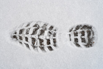 Trace of shoe on fresh wet white snow. Winter season.