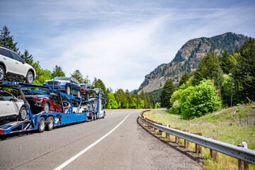 Powerful big rig car hauler semi truck transported cars on the hydraulic modular semi trailer...