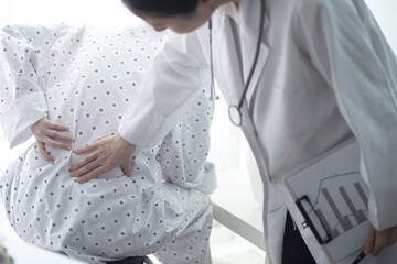 Doctor examining patient's back pain