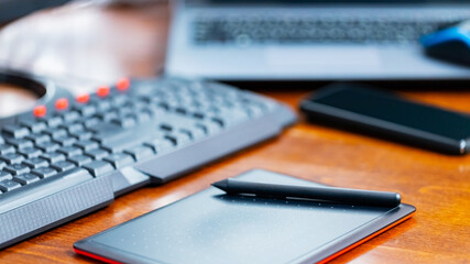 Remote work graphic designer. Freelancer workplace. Laptop, smartphone and graphic tablet in the workplace