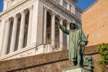 Detail of the statue of Cola di Rienzo, with the colonnade of the altar of the homeland from the steps of the Campidoglio, in the center of Rome. On a spring day with blue sky. Italy.