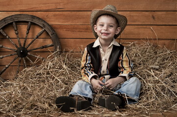 Happy child smiles. A portrait of a kid in a cowboy costume rejoices and dreams of adventure  in the Wild West. - 436327521
