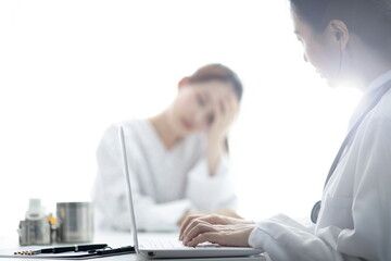 Doctor checking patient's headache in office