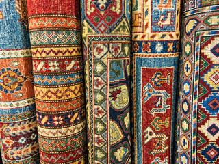 Handwoven rugs rolled up and lined up in a shop