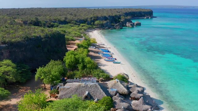 Aerial forward over thatched roofs of huts at Cueva de los Pescadores, Pedernales