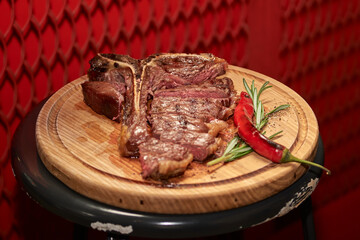 T bone Beef Grilled steak meat with rosemary branch, pepper, salt and glass of beer in restaurant