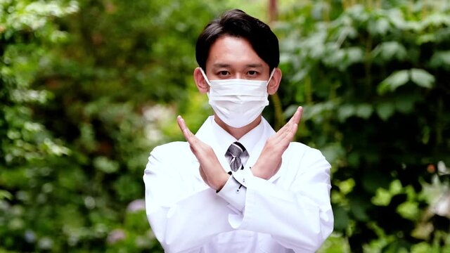 マスクをして不正解を示す男性医師