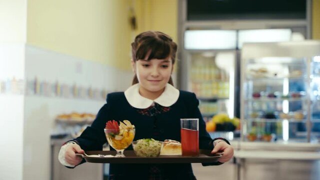 A schoolgirl in the school cafeteria.