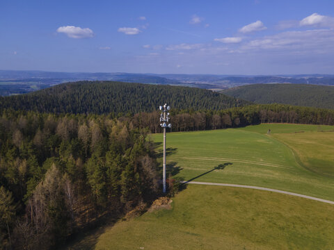 Landscape with a cell tower in the field on a sunny day - Powered by Adobe