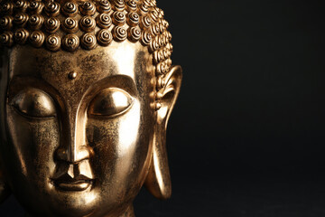 Beautiful golden Buddha sculpture on black background, closeup. Space for text