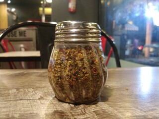Closeup shot of oregano and chilli flakes on table