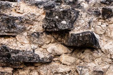 Abstract background of surface of rocks.  Close up view of grey and black weathered stonewall texture. Old vintage brick construction from year 1226. Old rough granite rock structure.